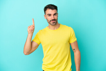 Fototapeta premium Young caucasian man isolated on blue background pointing up a great idea