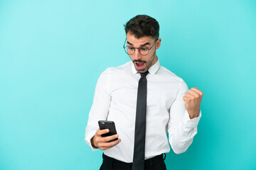 Business caucasian man isolated on blue background surprised and sending a message
