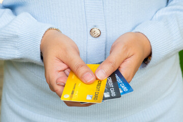 Woman holding several credit cards and he is choosing a credit card to pay and spend Payment for...