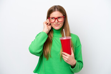Young caucasian woman drinking soda isolated on white background frustrated and covering ears