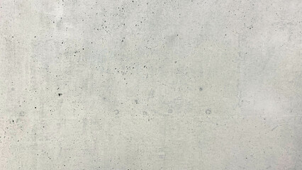 Close-up of an exposed concrete wall surface with fine air holes and raw construction marks