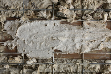 Background with elements of cement mortar scattered on a wall with a grid