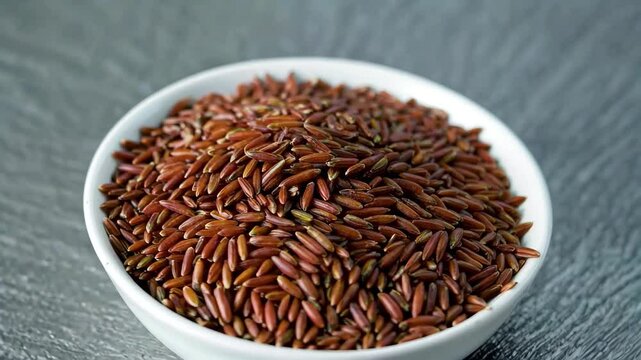 a close up of a bowl of red rice on a table
