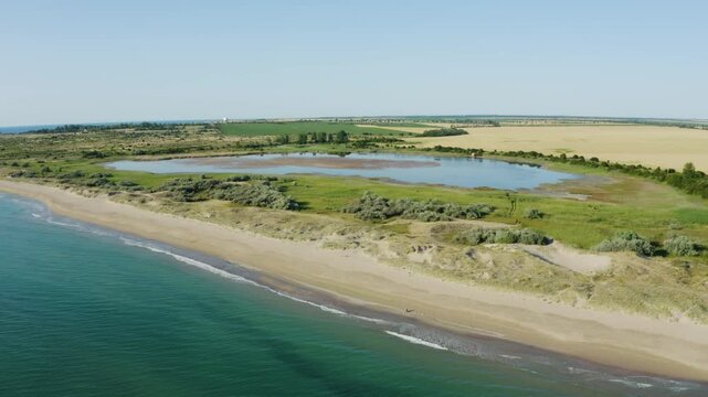 Establishing aerial footage of a lake near the ocean