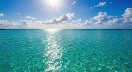 Calm turquoise sea with sun reflection and blue sky