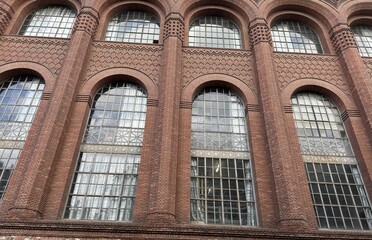 Facade of a typical house with brick walls and arched windows
