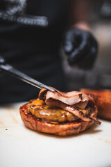 Chef Putting Bacon Inside A Burger During Preparation 