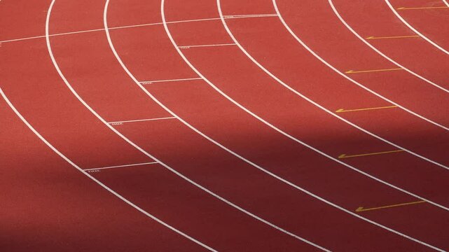 Rubberized artificial racing lane surface for track athletics, white lines and curved in the stadium.