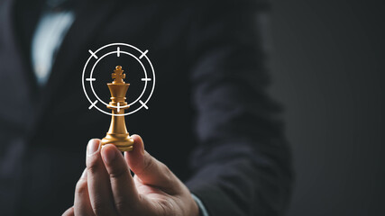 A person in a suit holds a chess piece, symbolizing strategy and focus, with a target overlay...