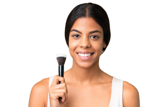 Young woman over over isolated chroma key background holding makeup brush and whit happy expression