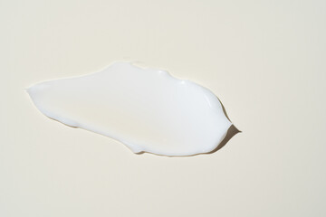 Luxurious cream dabbed and blended on neutral surface, highlighting smooth application for...