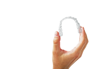 Human hand showing clear dental aligner on clean white background, closeup layout for oral care and orthodontic health concept presentation