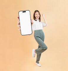 Confident Asian woman holding big smartphone mockup of blank screen and smiling on beige color...