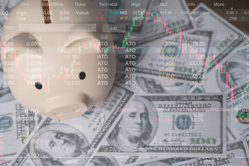 A piggy bank sits atop a bed of cash, surrounded by stock market data, symbolizing savings and...