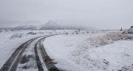 Empty frozen dangerous road after snowstorm. Icelandic mountain landscape Arnarstapi Snaefellsnes...
