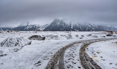 Empty frozen dangerous road after snowstorm. Icelandic mountain landscape Arnarstapi Snaefellsnes...