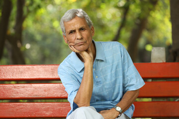 Portrait of a indian deep thinking old man at park