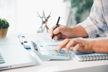Accountant working on desk using calculator for calculate finance report in office. business...