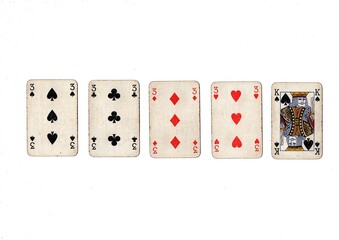 A poker hand of old grubby playing cards isolated on a white background.