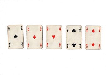 A poker hand of old grubby playing cards isolated on a white background.
