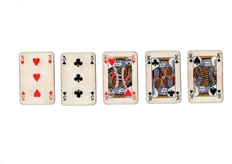 A poker hand of old grubby playing cards isolated on a white background.