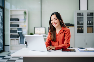 Business woman using tablet and laptop for doing math finance on an office desk, tax, report