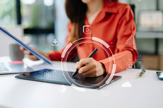 Creative Asian woman using stylus on digital tablet with holographic UI overlay. Concept of futuristic design, UX UI, innovation