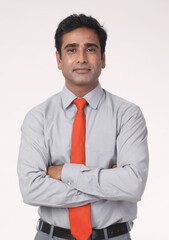 Indian smiling businessman or corporate man looking at camera with Arms Crossing Over her Stomach. isolated on grey studio background. Concept : Business Man