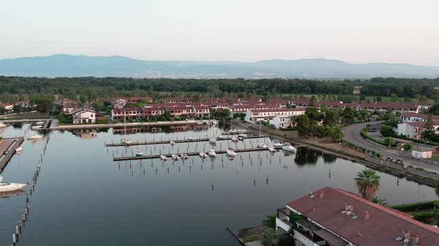 A drone over a small town on a lake. Marinas, Cloudy summer sunset. Sibari, Italy.