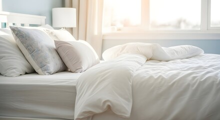 Obraz premium A bright bedroom with a white bed pillows and duvet near a window with natural light coming through