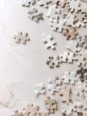 Scattered neutral-toned jigsaw puzzle pieces on a marble surface; some pieces are isolated, others clustered