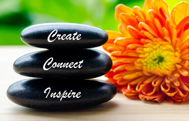 Stack of zen stones with the word create next to vibrant flower