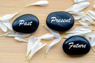 Zen stones labeled past, present, future on calming background for mindfulness