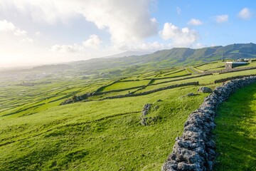 Rolling Green Fields Segmented by Ancient Stone Walls Leading to Distant Volcanic Hills on Terceira...