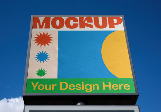 Blank urban advertising panel ready for customization in a city setting with clear blue sky and soft clouds above. PSD template mockup