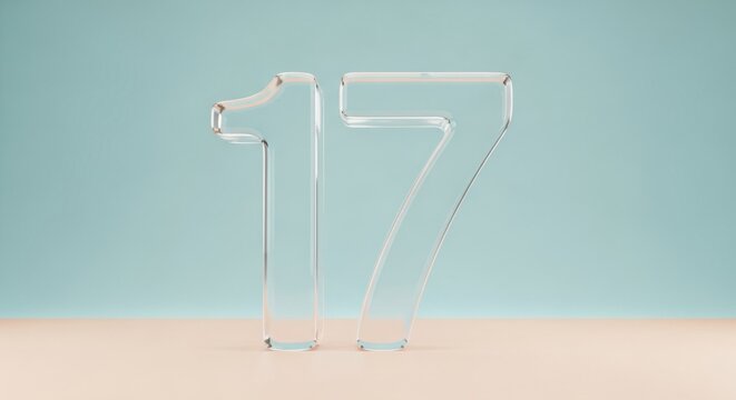 transparent glass number seventeen standing on beige surface against pastel blue background