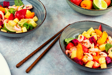 Fresh shrimp salad with colorful fruits.