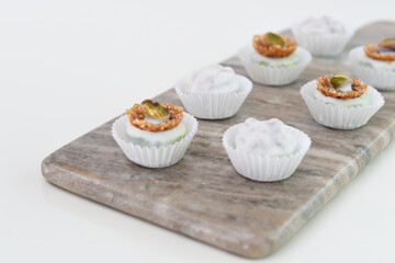 Assorted White Chocolate and Nut Truffles mini dessert bites on Marble Board closeup side view Sweet Dessert Treats Display