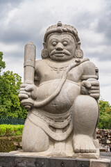 Fototapeta premium Vertical view of stone statue of dvarapala protector guardian at Candi Sewu ancient buddhist temple, Klaten, Central Java, Indonesia