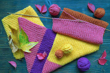 Autumn.  Knitting scarf, balls of wool and knitting needles. Colorful autumn leaves
