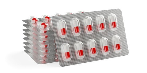 Red and white pill capsules in pill blister pack stacked and leaning in front on white background, medicine, pharmacy or drug concept