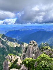 “Majestic Granite Peaks and Lush Forest under Dramatic Cloudy Sky – Scenic Chinese Mountain Landscape”