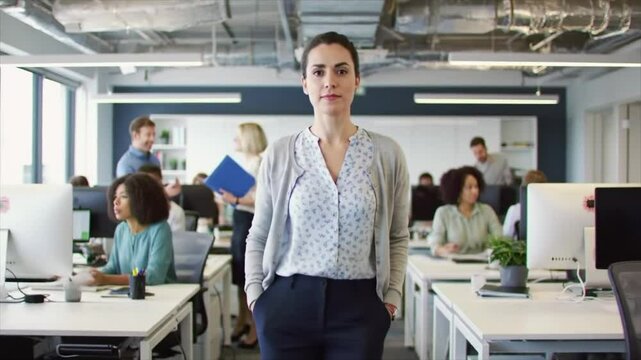 Team of professionals engaged in collaborative work in a modern office setting. Ethnically diverse individuals actively communicate and interact at their desks, showcasing teamwork and productivity