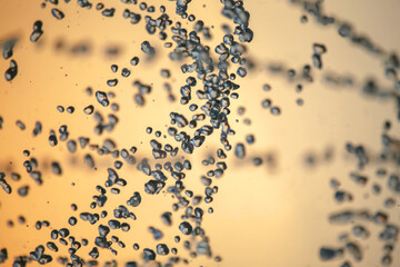 silhouettes of drops falling water fountain against the backdrop of the setting sun