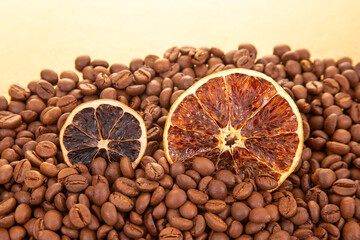 Rustic still life featuring dried orange segments scattered over a bed of rich, roasted coffee...