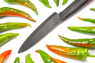 ceramic knife and green hot peppers on a white background. cooking vegetables for food