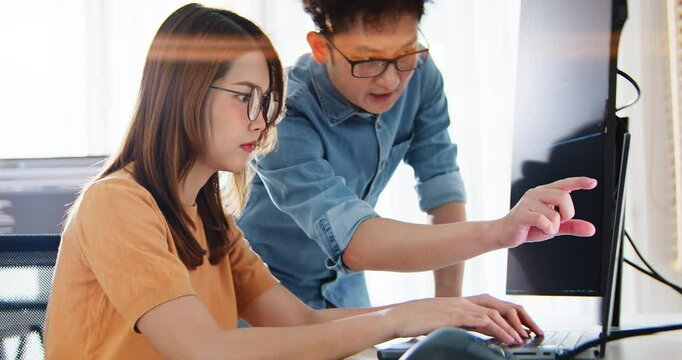 Asian male, female programming developer work together at home office, brainstorm discussion. Information technology, software engineer programmer coding job, man and woman coworker teamwork concept