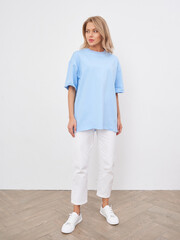 Stylish blonde woman in casual clothing posing in studio setting