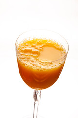A refreshing glass of freshly squeezed orange juice with a frothy top, served in a elegant clear wine glass against a clean white background. Perfect for food, beverage, and healthy lifestyle themes.