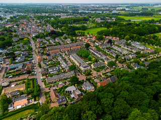 Aerial view of a peaceful suburban neighborhood surrounded by lush greenery, residential houses,...